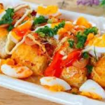 Nguyên liệu làm bánh mì nướng muối ớt Bánh mì: 3 cái bánh mì khoảng 100g Bơ: 15g Muối tôm: 1 muỗng Ruốc: khoảng 3 muỗng Chà bông: 3 muỗng Xúc xích: 1 cây Trứng cút: 5 quả Hành lá cắt nhỏ Sa tế tôm: 1,5 muỗng ( tùy theo khẩu vị của mọi người nếu ăn cay hơn có thể cho thêm nếu muốn) Dầu ăn: khoảng 10 muỗng Ớt bột: 1 muỗng Sốt mayonnaise: chuẩn bị 1 chai để xịt đều lên trên bề mặt Đường: 1/4 muỗng Muối 1/5 muỗng