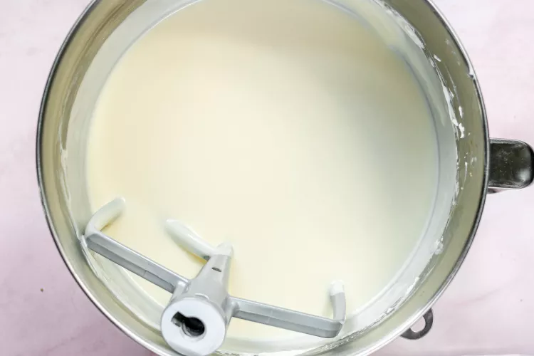 Cắt cream cheese thành từng miếng cho vào tô của máy trộn bột. Trộn ở tốc độ trung bình trong 4 phút cho đến khi mịn, mềm như kem. Thêm đường và đánh thêm 4 phút nữa.

Kế tiếp cho thêm muối, vani trộn đều cho đến khi hòa quyện. Thêm từng quả trứng vào, trộn ở tốc độ thấp trong 30 giây sau mỗi lần thêm. Hãy nhớ cạo các cạnh của tô và cạo những phần phô mai kem dày hơn dính vào đáy máy trộn mà phụ kiện cánh khuấy không kết hợp được.

Tiếp đến cho thêm kem chua trộn ở tốc độ trung bình cho đến khi hòa quyện.

Cuối cùng cho thêm heavy cream vào trộn ở tốc độ thấp cho đến khi hòa quyện.