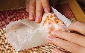Hướng dẫn cuốn chả giò đẹp
Lấy bánh tráng trải lên mặt phẳng, cho phần nhân vào 1/3 phần bánh gấp 2 mép bánh lại sau đó dùng lực ngón tay cuộn tròn phần bánh lại.