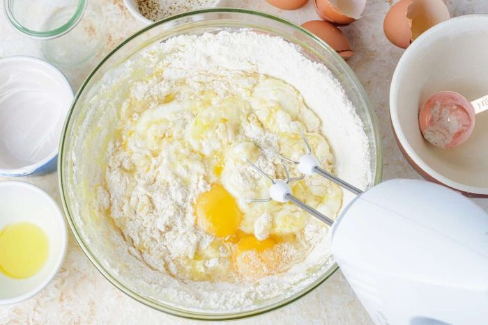 Trộn lòng trắng trứng: Nhẹ nhàng trộn lòng trắng trứng vào hỗn hợp bột. Lưu ý trộn đều từ dưới lên trên để không làm vỡ bọt khí.
