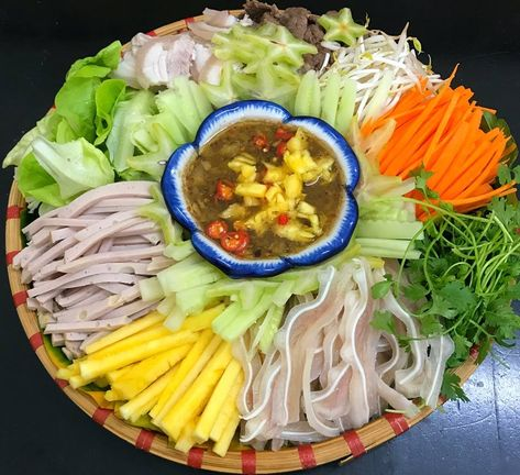 2. Sơ Chế Các Nguyên Liệu
Thịt heo: Rửa sạch và thái mỏng. Bạn có thể luộc thịt trong khoảng 15 phút, sau đó thái thành miếng vừa ăn.
Tai heo: Rửa sạch với nước cốt chanh. Luộc 15 phút, sau đó thái thành những miếng mỏng vừa ăn.
Tôm: Lột vỏ, rút chỉ đen, rửa sạch. Sau đó, luộc tôm trong nước sôi khoảng 5-7 phút rồi vớt ra để ráo.
Chả lụa: Cắt thành những lát mỏng.
Nem chua: Cắt thành những lát mỏng
Rau củ: Cà rốt và dưa leo gọt vỏ, sau đó thái sợi mỏng. Hành tây thái mỏng và ngâm trong nước muối loãng để giảm độ hăng.
Rau thơm: Rửa sạch húng quế và rau răm.
Bánh tráng nướng: Cắt thành miếng nhỏ hoặc nướng qua để bánh tráng giòn hơn.