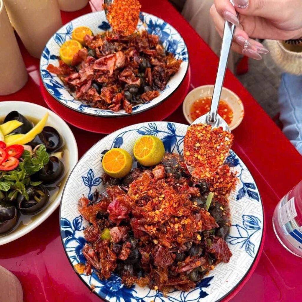 Lấy một cái tô lớn múc ốc đã luộc cùng với nước vào. Cho thêm ớt bột và tắc để tăng hương vị của món ốc. Cuối cùng là rắc hành phi lên trên của bề mặt ốc.
