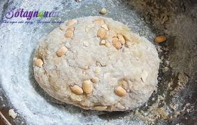 Bước 3: Trộn Bột
Cho hỗn hợp nước đường vào âu sau đó múc từng thìa bột nếp vào, trộn đều tới khi thấy bột đặc lại thì cho ra bàn sạch.
Thêm phần bột nếp còn lại cùng với lạc đã giã dập và nhồi thật kỹ. Bạn nên để lại một chút bột nếp khô để làm bột áo.
Nhồi tới khi được 1 khối bột dẻo và hơi cứng là được, bọc kín lại rồi để bột nghỉ 20 phút.