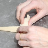 Cuộn bánh: Từ đáy mỗi tam giác, cuộn chặt về phía đỉnh, uốn cong hai đầu để tạo hình sừng bò.