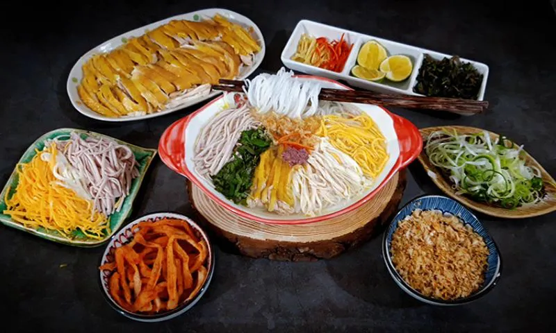Chuẩn Bị Nguyên Liệu
Thịt gà: Luộc gà vừa chín tới, sau đó lọc lấy thịt, thái sợi nhỏ. Phần xương giữ lại để ninh nước dùng.
Xương lợn: Rửa sạch, chần qua nước sôi để loại bỏ tạp chất, sau đó cho vào nồi ninh cùng xương gà.
Tôm khô: Ngâm nước ấm cho mềm, sau đó giã nhỏ, sao vàng để làm ruốc tôm.
Thịt thăn lợn: Thái hạt lựu nhỏ, ướp gia vị, rang thơm để làm ruốc sỏi.
Giò lụa: Thái chỉ như sợi bún.
Trứng: Trứng gà tráng thái thành sợi mỏng
Củ cải: cắt thành sợi
Rau răm: Rửa sạch, thái rối