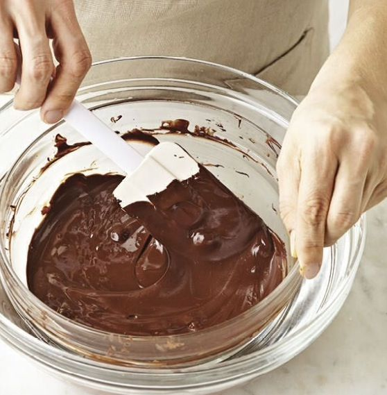 Bước 7: Làm lớp kem phủ bên ngoài bánh chocolate
Chuẩn bị socola: Cắt nhỏ socola thành các mảnh vụn hoặc sử dụng socola chip để dễ dàng tan chảy.
Đun nóng kem tươi: Cho whipping cream vào nồi, đun nóng trên lửa nhỏ cho đến khi kem gần sôi (khoảng 80°C). Lưu ý không để kem sôi bùng lên.
Kết hợp socola và kem: Đổ kem nóng vào tô chứa socola đã cắt nhỏ. Để yên trong khoảng 5–10 phút để socola tự tan chảy.
Khuấy đều: Sau khi socola đã tan, dùng phới lồng hoặc thìa khuấy đều đến khi hỗn hợp mịn màng và đồng nhất.
Để nguội: Để ganache nguội ở nhiệt độ phòng cho đến khi đạt độ đặc mong muốn. Nếu muốn lớp phủ đặc hơn, bạn có thể cho vào tủ lạnh khoảng 30 phút trước khi sử dụng.