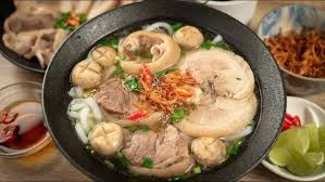 Bước 4: Trình Bày và Thưởng Thức

Trụng bún cho vào tô, xếp giò heo, cà chua, hành lá và giá lên trên.

Múc nước dùng nóng hổi vào tô, rắc thêm hành phi, sa tế và tiêu xay.

Ăn kèm với rau sống, nước mắm mặn tiêu xay hay tỏi ớt tùy khẩu vị.