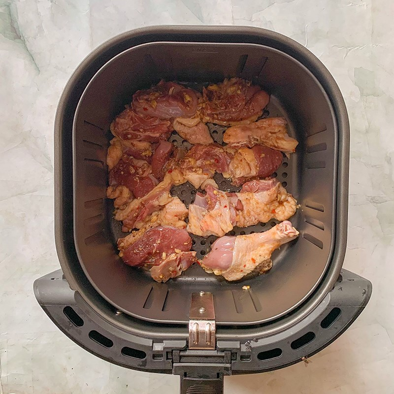 Bước 4: Nướng vịt
Làm nóng nồi chiên không dầu ở nhiệt độ 120°C trong 5–7 phút.
Lót giấy bạc vào lòng nồi, quét một lớp dầu mỏng lên trên.
Xếp thịt vịt vào nồi, không chồng chéo để thịt chín đều.
Nướng ở nhiệt độ 200°C trong 10 phút.
Sau 10 phút, lật mặt thịt và nướng thêm 5–7 phút ở 180°C cho đến khi thịt chín vàng đều.
