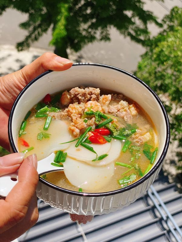 Bước 3: Hoàn Thiện Món Ăn
Cho bánh phồng tôm đã ngâm vào nồi, nấu thêm 2–3 phút.
Khuấy đều bột năng pha loãng vào nồi để tạo độ sánh nhẹ cho nước lèo.
Cho trứng cút vào, nấu thêm 1 phút.
Tắt bếp, rắc hành lá và rau mùi lên trên.
Múc ra tô, ăn kèm với sa tế và rau sống nếu thích.