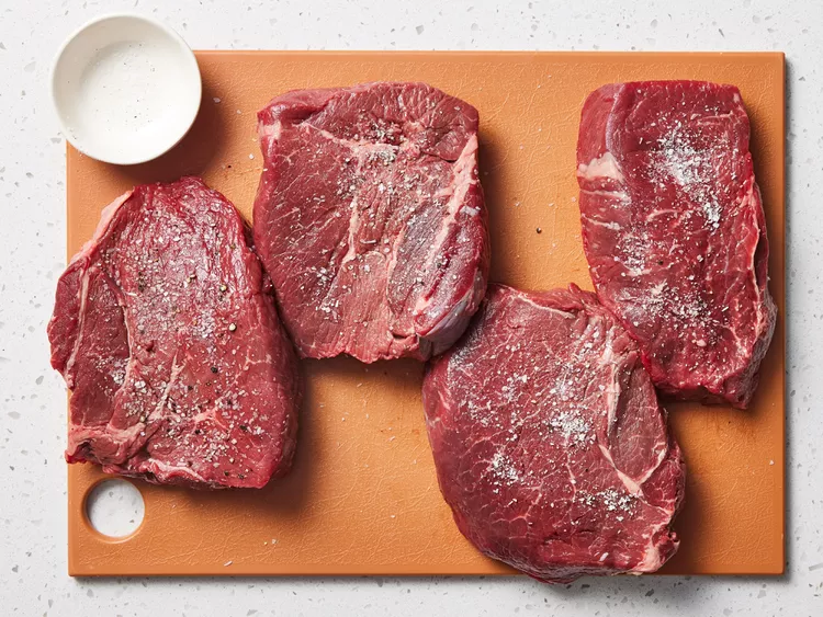 Bước 1: Chuẩn Bị Thịt
Trước khi chế biến, bạn cần rã đông beefsteak bằng cách ngâm nguyên gói thịt vào nước lạnh trong khoảng 5-7 phút. Sau đó, cắt túi, lấy thịt ra và đặt lên đĩa có lót khăn sạch để thấm hết nước. Ngay trước khi áp chảo, nêm gia vị lên beefsteak với 1/2 thìa cà phê muối thô và 1 thìa cà phê tiêu đen.