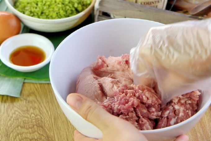 ước 1: Trộn nguyên liệu
Trộn giò sống, thịt xay, gia vị (nước mắm, hạt tiêu, muối, đường, hành khô phi).
Cho cốm (đã ráo nếu khô) vào và trộn nhẹ tay để tránh làm nát hạt cốm.
Mẹo giúp nhân dẻo: quết kỹ bằng tay hoặc máy cho hỗn hợp kết dính tốt, tạo khối mịn .