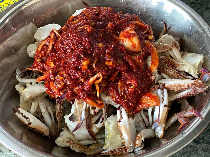 Ướp ghẹ trong sốt cay Hàn Quốc
Cho ghẹ đã sơ chế vào hộp hoặc tô sạch.
Rưới nước sốt đã nguội lên ghẹ, trộn nhẹ để sốt thấm đều.
Trang trí: rắc mè rang, hành lá, ớt sừng thái lát (xanh – đỏ).
Ăn ngay hoặc ướp trong tủ lạnh khoảng 1–2 giờ nếu muốn thấm vị hơn (món này có thể ăn luôn khác với ghẹ ngâm tương cần để lâu.