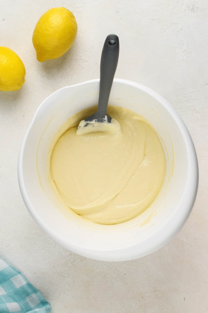 Bước 2: Chuẩn bị nhân cheesecake
Cream cheese mềm ở nhiệt độ phòng → đánh mịn với đường và sour cream/heavy cream.
Thêm vỏ chanh + nước cốt chanh, vanilla, muối → đánh nhẹ đến khi hoà quyện.
Kết thúc bằng đánh từng quả trứng một, tránh overmix để cheesecake không bị rỗ khí và xẹp khi nguội.
