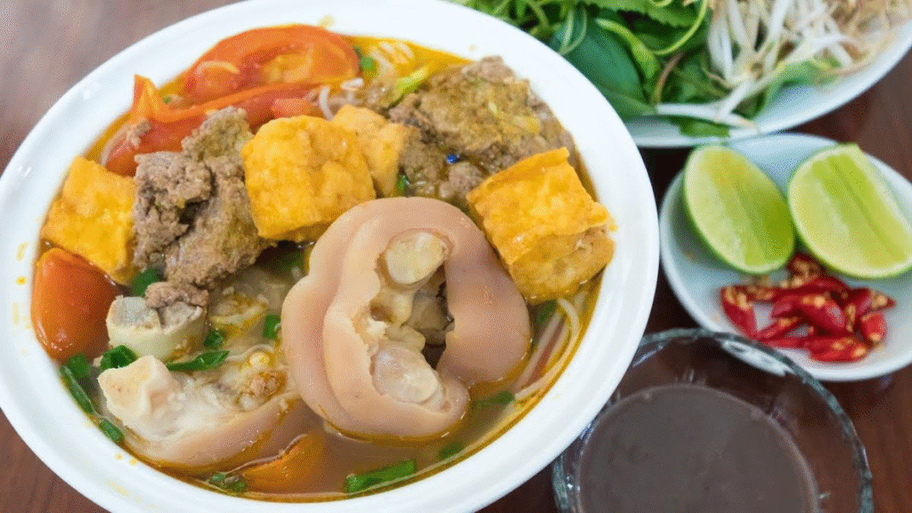 3. Bún riêu cua – Hương vị dân dã miền Bắc
Bún riêu cua là món ăn dân dã nhưng rất được ưa chuộng ở miền Bắc. Nước dùng được nấu từ cua đồng giã nhuyễn, tạo nên vị ngọt tự nhiên. Sợi bún mềm mại, ăn kèm với đậu phụ chiên, huyết luộc và rau sống. Món ăn này thường được ăn vào bữa sáng hoặc trưa, mang đến cảm giác thanh mát và dễ chịu.