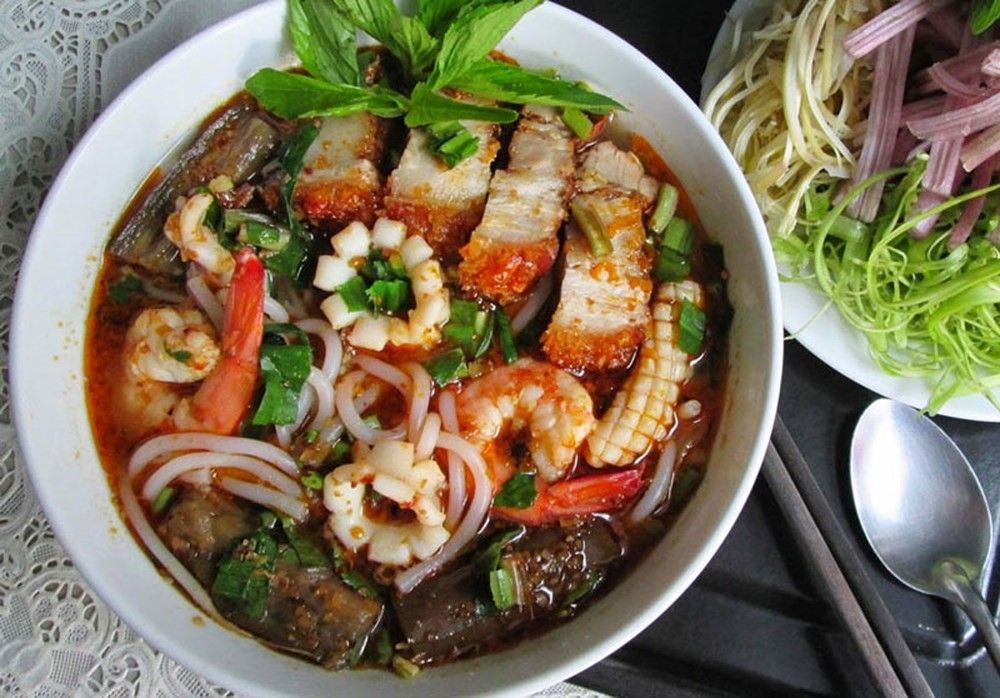 4. Bún mắm – Đặc sản miền Tây Nam Bộ
Bún mắm là món ăn đặc trưng của miền Tây Nam Bộ, nổi bật với hương vị đậm đà của mắm cá linh hoặc cá sặc. Nước dùng được nấu từ mắm, kết hợp với tôm, thịt heo quay, chả, cà tím và các loại rau sống như bông điên điển, kèo nèo. Món ăn này mang đến hương vị đặc trưng, khó quên cho thực khách.