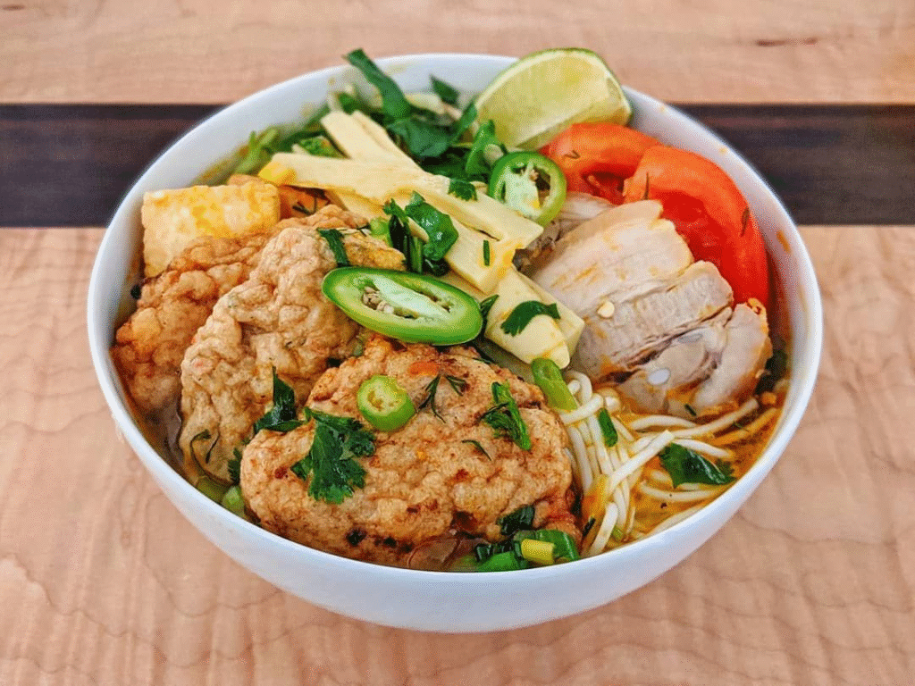5. Bún chả cá – Hương vị biển miền Trung
Bún chả cá là món ăn nổi tiếng của miền Trung, đặc biệt là thành phố Nha Trang. Nước dùng được nấu từ xương cá, kết hợp với chả cá chiên và hấp, tạo nên hương vị thanh ngọt, dễ chịu. Sợi bún mềm mại, ăn kèm với rau sống và nước mắm chua ngọt. Món ăn này thường được thưởng thức vào bữa sáng, mang đến cảm giác nhẹ nhàng và bổ dưỡng.