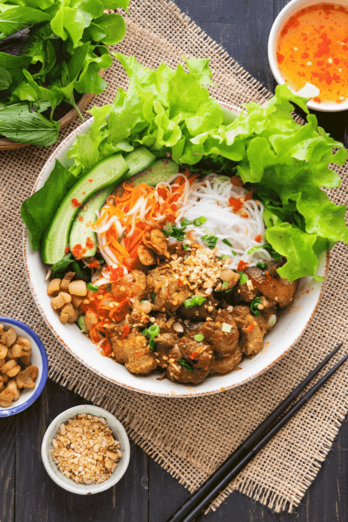 6. Bún thịt nướng – Đặc sản miền Nam
Bún thịt nướng là món ăn phổ biến ở miền Nam, đặc biệt là thành phố Hồ Chí Minh. Thịt heo được tẩm ướp gia vị, nướng trên than hoa, ăn kèm với bún tươi, rau sống, đậu phộng rang và nước mắm chua ngọt. Món ăn này mang đến hương vị thơm ngon, dễ ăn và được ưa chuộng vào mọi thời điểm trong ngày.