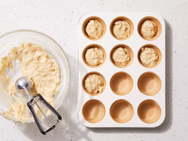 Thêm hạt
Nếu dùng hạt óc chó hoặc chocolate chip, trộn nhẹ vào lúc cuối.

Đổ bột vào khuôn
Chia đều bột vào khuôn, nên đổ khoảng ¾ khuôn để bánh có không gian nở tốt.