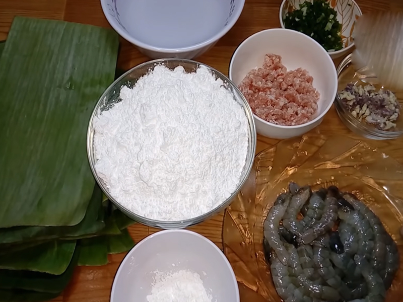 Nguyên liệu làm bánh nậm miền Trung
1. Nguyên liệu làm bột
Bột gạo: 250g
Bột năng (hoặc bột sắn): 50 g
Nước lọc: khoảng 600 ml (tỷ lệ bột : nước khoảng 1:2)
Một chút dầu ăn, đường, muối để bột thêm dẻo và thơm
2. Nguyên liệu nhân tôm – thịt
Tôm tươi: khoảng 150 g
Thịt heo nạc (vai): khoảng 150 g
Hành tím, hành lá, tỏi, ớt (tuỳ chọn)
Gia vị cần thiết: nước mắm, đường, muối, tiêu, hạt nêm, và dầu màu điều