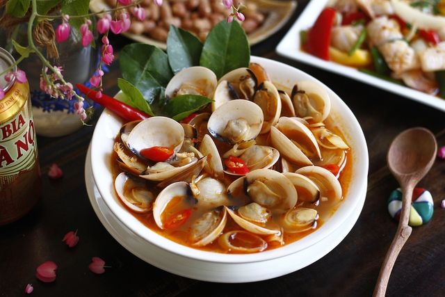 Cách làm nghêu hấp Thái chua cay 

Nguyên liệu:

Nghêu tươi: 1,5kg

Sốt lẩu Thái, nước dừa tươi, sả, gừng, hành tím, ớt hiểm, lá húng quế

Gia vị: nước mắm, hạt nêm, đường

Cách làm:

Cách sơ chế nghêu: Nếu muốn nghêu được sạch không còn cát, bạn nên ngâm nghêu với nước vo gạo, hoặc nước với ớt cắt. Ngâm khoảng 3 tiếng, sau đó rửa lại với nước sạch và để ráo nước.

Phi thơm: dầu ăn – hành tím, sả đập dập, gừng lát, ớt thái — phi cho thơm.

Nấu nước Thái: cho nước dừa tươi lên bếp và cho nước vào cho sôi khoảng 60ml, thêm vào 1/2 gói lẩu thái, 1 muỗng tương ớt , gia vị: 1/2 muỗng hạt nêm, 1 muỗng nước mắm, 1 muỗng giấm ăn nước mắm, 1 muỗng đường, đun lửa liu riu

Hấp nghêu: bỏ nghêu vào nồi, lắc đều để nghêu ngấm gia vị. Đậy nắp, đun cho đến khi nghêu mở miệng là chín.
