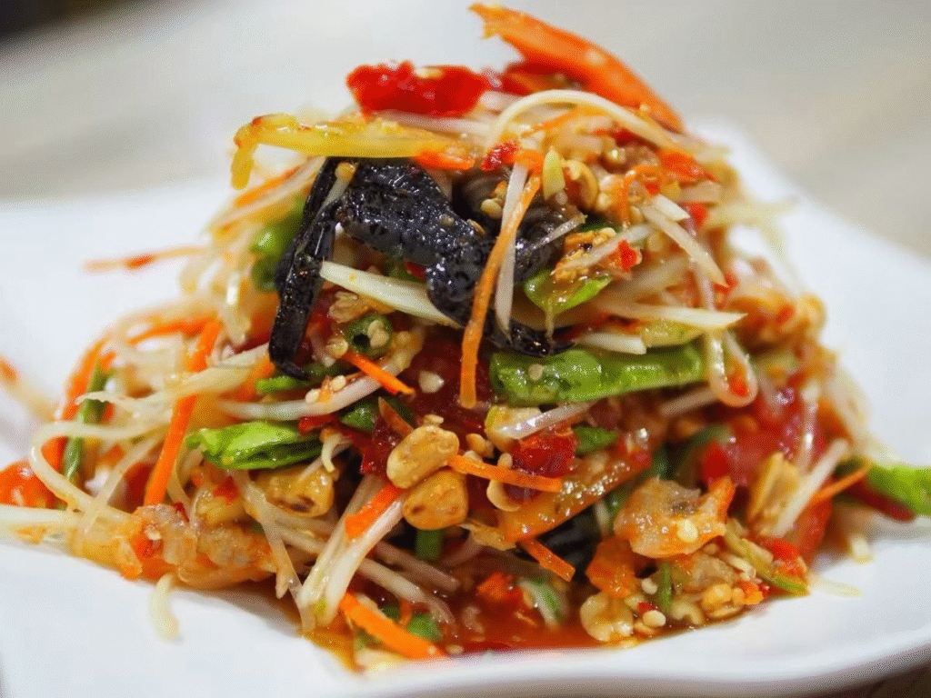 Trộn đu đủ và ba khía
Cho đu đủ sợi + ba khía đã sơ chế vào tô lớn.

Thêm rau thơm
Cho rau răm, ngò gai, rau mùi (nếu dùng) vào để tạo hương và độ tươi mát.

Rưới nước trộn gỏi
Rưới phần nước trộn đã pha đều lên hỗn hợp đu đủ + ba khía + rau thơm. Dùng đũa trộn đều, nhẹ nhàng để đu đủ không bị nát.

Nêm nếm hoàn thiện
Nếm thử: nếu thấy hơi chua thì thêm đường, nếu mặn quá thì thêm nước cốt chanh/nước lọc, nếu chưa đậm vị ba khía thì có thể thêm chút ba khía hoặc nước mắm Thái.

Ướp ngắn
Để hỗn hợp gỏi nghỉ khoảng 10‑15 phút trước khi ăn để các vị hòa quyện. Nếu để lâu quá, đu đủ sẽ mất độ giòn.

Trang trí & thưởng thức
Khi ăn, rắc thêm lạc rang (đậu phộng) hoặc hạt điều, đôi khi cho thêm hành phi nếu thích, để tăng độ giòn và mùi thơm. Ăn kèm bánh phồng tôm hoặc bánh đa nướng sẽ rất tuyệt.