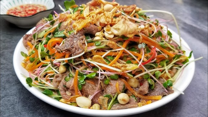 Gỏi bò trộn rau mầm là một món ăn nhẹ nhàng nhưng đầy tinh tế, hòa quyện giữa vị ngọt mềm của thịt bò, độ giòn mát của rau mầm và vị chua, cay, mặn, ngọt của nước trộn. Món ăn này rất hợp để làm món khai vị, ăn trưa nhẹ hoặc ăn trong những ngày nóng nực bởi tính thanh mát và dễ tiêu hóa.

Rau mầm vốn đã nổi tiếng là loại thực phẩm giàu vitamin, khoáng chất và chất chống oxy hóa — kết hợp cùng thịt bò cung cấp protein, tạo nên bữa ăn cân bằng dinh dưỡng. Khi chế biến đúng cách, món gỏi bò trộn rau mầm không chỉ ngon mắt mà còn giúp bạn và gia đình bổ sung dưỡng chất tốt cho sức khỏe.

Bài viết này yêu bếp núc sẽ hướng dẫn chi tiết từng bước cách làm gỏi bò trộn rau mầm tại nhà— từ chọn nguyên liệu, sơ chế, cách làm đến mẹo nhỏ để món gỏi trở nên hoàn hảo.